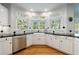Bright kitchen features granite countertops, stainless steel appliances, and a farmhouse sink at 415 Oak Laurel Ct, Johns Creek, GA 30022