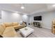 Comfortable basement living room with a sectional sofa, a white table and a television at 415 Oak Laurel Ct, Johns Creek, GA 30022