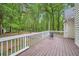 Exterior shot of a wood back deck overlooking a large, lush green backyard and wooded area at 5640 Rolling Oaks Dr, Cumming, GA 30040