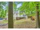 Back exterior view showing a deck and spacious lawn with mature trees and landscaping at 5640 Rolling Oaks Dr, Cumming, GA 30040