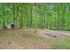 View of the spacious and wooded backyard with a storage shed on the left at 5640 Rolling Oaks Dr, Cumming, GA 30040