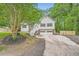 Charming home with a two-car garage, a well-maintained lawn, and beautiful, mature trees at 5640 Rolling Oaks Dr, Cumming, GA 30040