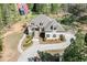 Aerial view of a beautiful home with a curved driveway and landscaped grounds at 6050 Eagle Close Ln, Sugar Hill, GA 30518