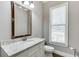 Bathroom with patterned wallpaper, granite countertops, and window at 6050 Eagle Close Ln, Sugar Hill, GA 30518