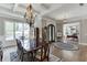 Bright dining room with hardwood floors, a chandelier, and views of the front yard and the office at 6050 Eagle Close Ln, Sugar Hill, GA 30518