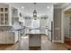 Well-lit kitchen with white cabinetry, stainless steel appliances, and a stylish center island at 6050 Eagle Close Ln, Sugar Hill, GA 30518