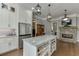 Open kitchen features large island, stone fireplace and stainless steel appliances at 6050 Eagle Close Ln, Sugar Hill, GA 30518