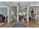 Open-concept living area with gleaming hardwood floors and views of the fireplace, living room, and staircase at 6050 Eagle Close Ln, Sugar Hill, GA 30518