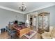 Well-lit home office with a chandelier, hardwood floors, built-in bookshelves, desk, and a large window at 6050 Eagle Close Ln, Sugar Hill, GA 30518