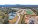 Aerial view of the community showing tennis courts and green sports fields in a well-maintained, amenity-rich neighborhood at 6680 Benchwood Path, Cumming, GA 30028