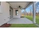 Covered back porch with ceiling fan overlooking a well-manicured backyard at 6680 Benchwood Path, Cumming, GA 30028