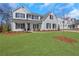 Charming two-story home with manicured lawn and classic white facade, complete with black shutters at 6680 Benchwood Path, Cumming, GA 30028