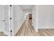 Hallway featuring wood floors, white trim and moulding and a stone fireplace in the living room at 6680 Benchwood Path, Cumming, GA 30028
