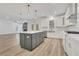 Open-concept kitchen with island, stainless appliances, and views of living room at 6680 Benchwood Path, Cumming, GA 30028