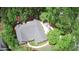 An aerial view of a residential home featuring landscaped yard, driveway, and surrounding lush trees at 7675 Lanier View Rdg, Cumming, GA 30041