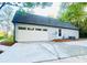 Spacious concrete driveway leading to a two-door garage with ample parking and new roof at 7675 Lanier View Rdg, Cumming, GA 30041