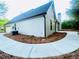 Home's exterior showing light siding, a dark roof, and a well-maintained side yard at 7675 Lanier View Rdg, Cumming, GA 30041