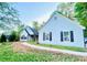 Charming single-story home featuring light blue siding, dark shutters, and a well-manicured lawn at 7675 Lanier View Rdg, Cumming, GA 30041