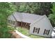 Charming single-story home with gray siding, dark shutters, and mature trees at 7675 Lanier View Rdg, Cumming, GA 30041