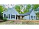 Charming single-story home with light-blue siding, black shutters, and a welcoming entrance with stone accents at 7675 Lanier View Rdg, Cumming, GA 30041