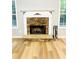 Cozy living room features a stone fireplace and light wood floors at 7675 Lanier View Rdg, Cumming, GA 30041