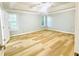 A light filled main bedroom features tray ceilings and light wood floors at 7675 Lanier View Rdg, Cumming, GA 30041