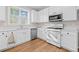 Well-lit kitchen featuring white cabinets, stainless steel appliances, and hardwood flooring at 3317 Ridgemill Cir, Dacula, GA 30019