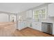 Stylish kitchen with white cabinets, stainless steel dishwasher, and open view to the living room at 3317 Ridgemill Cir, Dacula, GA 30019