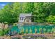 Charming water feature with detailed woodwork, stonework, a waterwheel and surrounded by lush foliage and flowers at 3317 Ridgemill Cir, Dacula, GA 30019