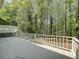 View of back deck with white wood railing overlooking trees at 1004 Westminister Ct, Woodstock, GA 30188