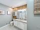 Bathroom featuring dual sinks, granite countertops, decorative lighting, and wood paneling at 1004 Westminister Ct, Woodstock, GA 30188