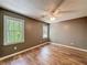 This bedroom features hardwood floors, a ceiling fan, and windows with natural light at 1004 Westminister Ct, Woodstock, GA 30188
