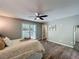 Bright bedroom with a ceiling fan, a cozy bed and a view of the green scenery outside the window at 1004 Westminister Ct, Woodstock, GA 30188