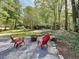 Cozy outdoor seating around a fire pit, surrounded by natural landscaping, offering a relaxed setting at 1004 Westminister Ct, Woodstock, GA 30188