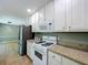 Well-lit kitchen boasts white cabinets and modern stainless steel refrigerator at 1004 Westminister Ct, Woodstock, GA 30188