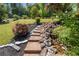 Landscaped backyard featuring a stone pathway, lush greenery, and a tranquil garden at 202 Carrington Estates Ct, Woodstock, GA 30188