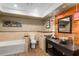 Bathroom showcasing a modern vanity, unique mirror, elegant lighting, and soaking tub at 202 Carrington Estates Ct, Woodstock, GA 30188