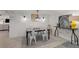 An inviting dining area features a modern table and chairs with an accent brick wall and decorative lighting at 202 Carrington Estates Ct, Woodstock, GA 30188