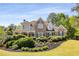 Charming brick home featuring lush landscaping, a covered porch, and classic architectural details at 202 Carrington Estates Ct, Woodstock, GA 30188