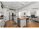 Open-concept kitchen with white cabinets, stainless steel appliances, and butcher block island flows into the living room at 202 Carrington Estates Ct, Woodstock, GA 30188