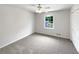This bedroom features neutral walls and flooring, a ceiling fan, and a window with natural light at 2390 Century Ln, Snellville, GA 30039