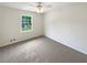 Bedroom features neutral colors, a ceiling fan, and natural light from the window at 2390 Century Ln, Snellville, GA 30039
