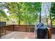 Cozy wooden back deck with a grill and lush green trees surrounding the property at 3365 Vintage Se Cir, Smyrna, GA 30080