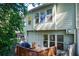 View of the wooden back deck and the home's exterior with large windows at 3365 Vintage Se Cir, Smyrna, GA 30080