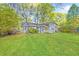 Spacious backyard showcasing the home's exterior and mature trees at 3839 Rosedale Ln, Douglasville, GA 30135