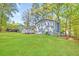 Home's exterior features a well-manicured backyard, mature trees, and a fenced-in area at 3839 Rosedale Ln, Douglasville, GA 30135