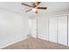 A spacious bedroom with a ceiling fan, carpet, and a closet with sliding doors at 3839 Rosedale Ln, Douglasville, GA 30135