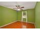 Bedroom features hardwood floors, a ceiling fan and a window with light drapes at 484 Aberdeen Dr, Stonecrest, GA 30083
