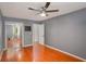 Bedroom with hardwood floors, ceiling fan, mirrored closet doors and plenty of natural light at 484 Aberdeen Dr, Stonecrest, GA 30083