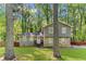 View of a two-story home with stone accents and gray siding surrounded by mature trees at 484 Aberdeen Dr, Stonecrest, GA 30083